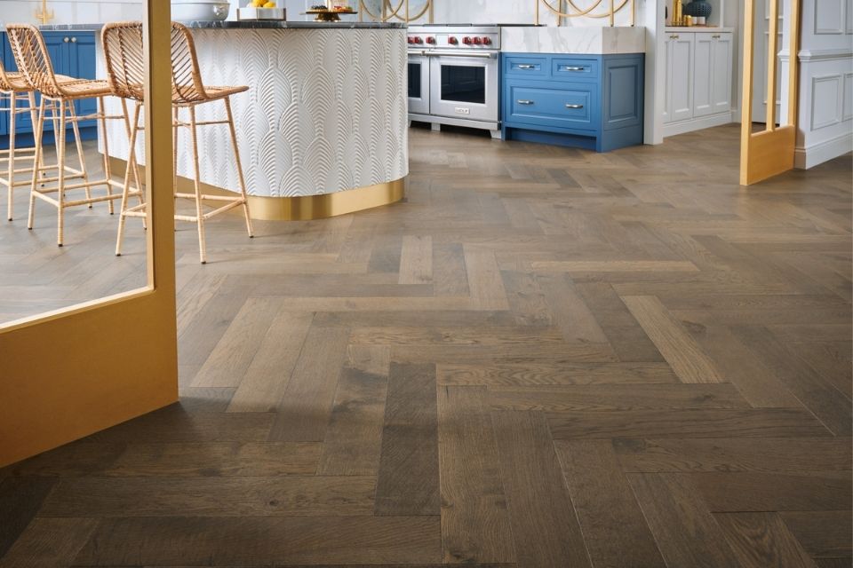 dark hardwood herringbone in modern kitchen with blue cabinetry